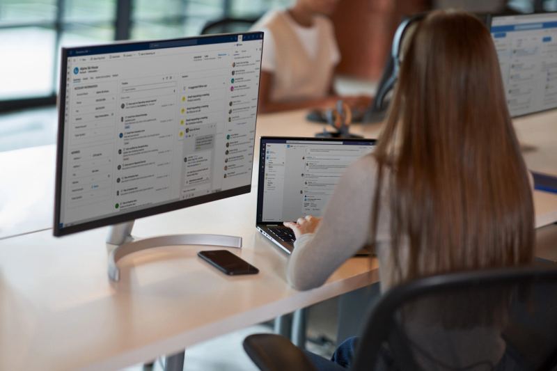 Office workers at monitors illustrating Microsoft Copilot and Dynamics workflow integration