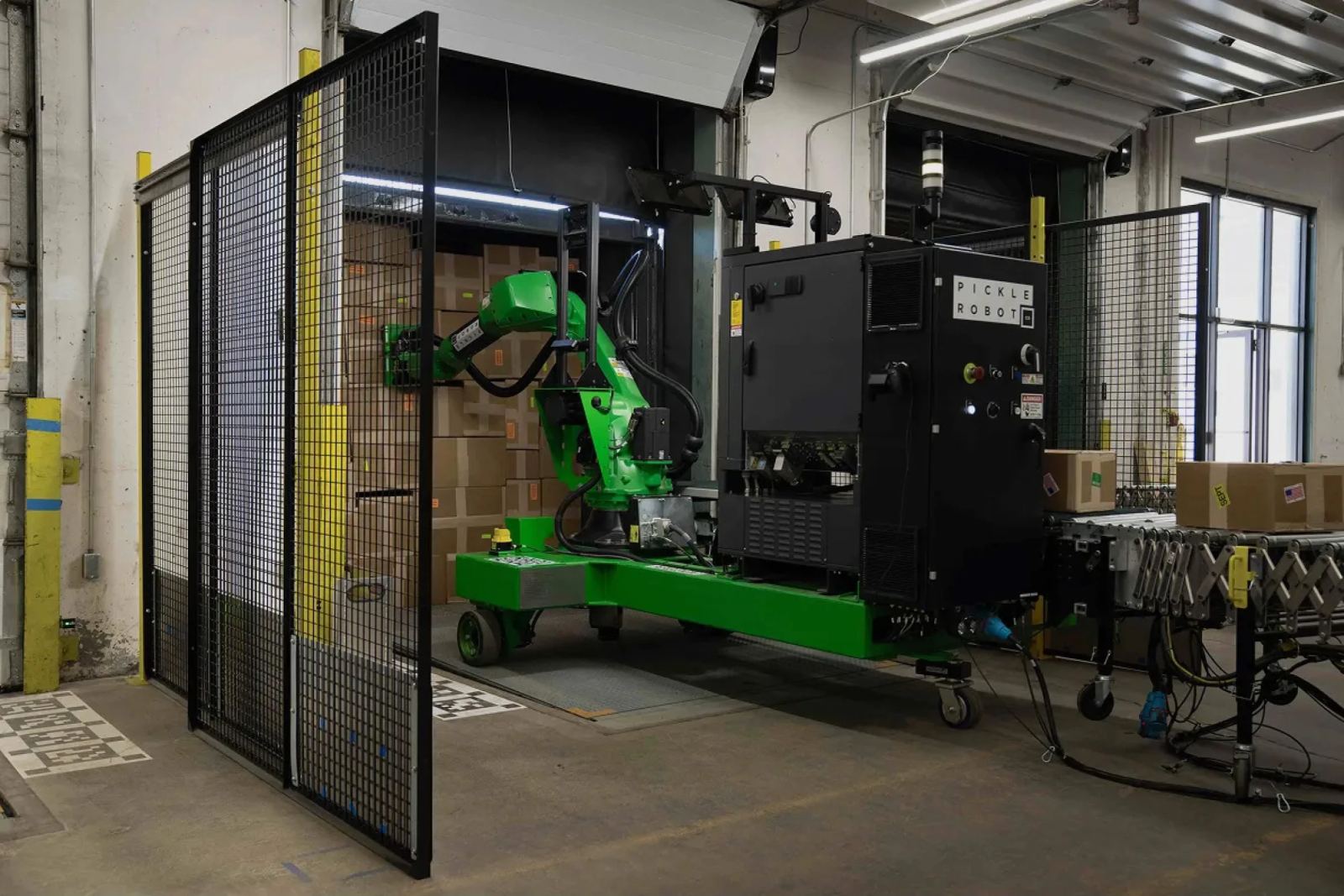 Warehouse robots unloading packages from a trailer and stacking mixed cases onto pallets