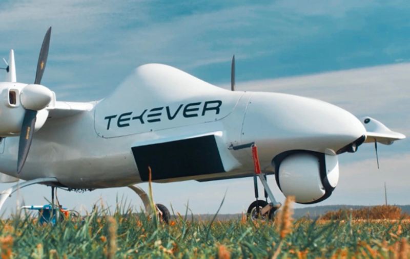 Military surveillance drone operating over a training range, representing industrial-scale autonomous systems procurement.