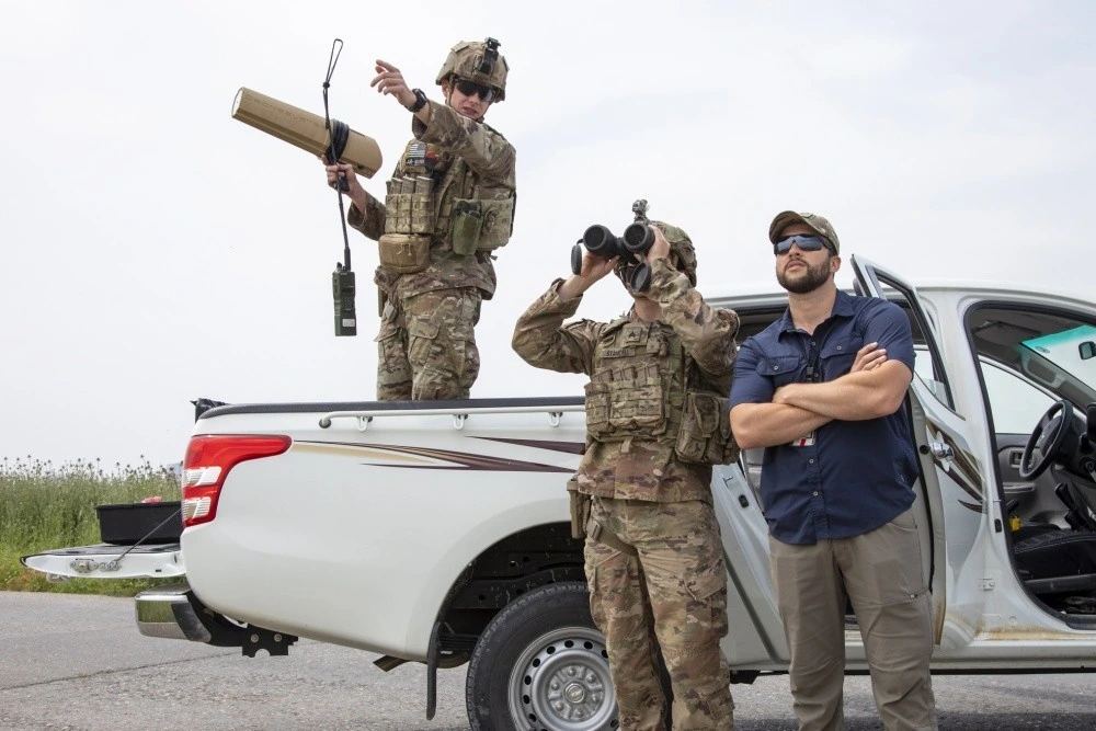 Military personnel operating a counter-drone system during a field exercise.