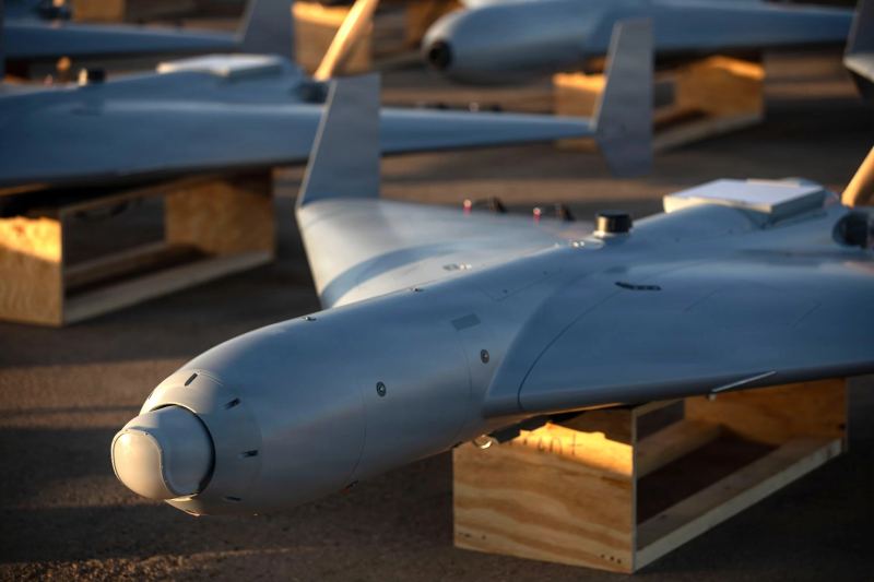 Vehículo aéreo no tripulado sobrevolando un campo de pruebas de defensa costera.