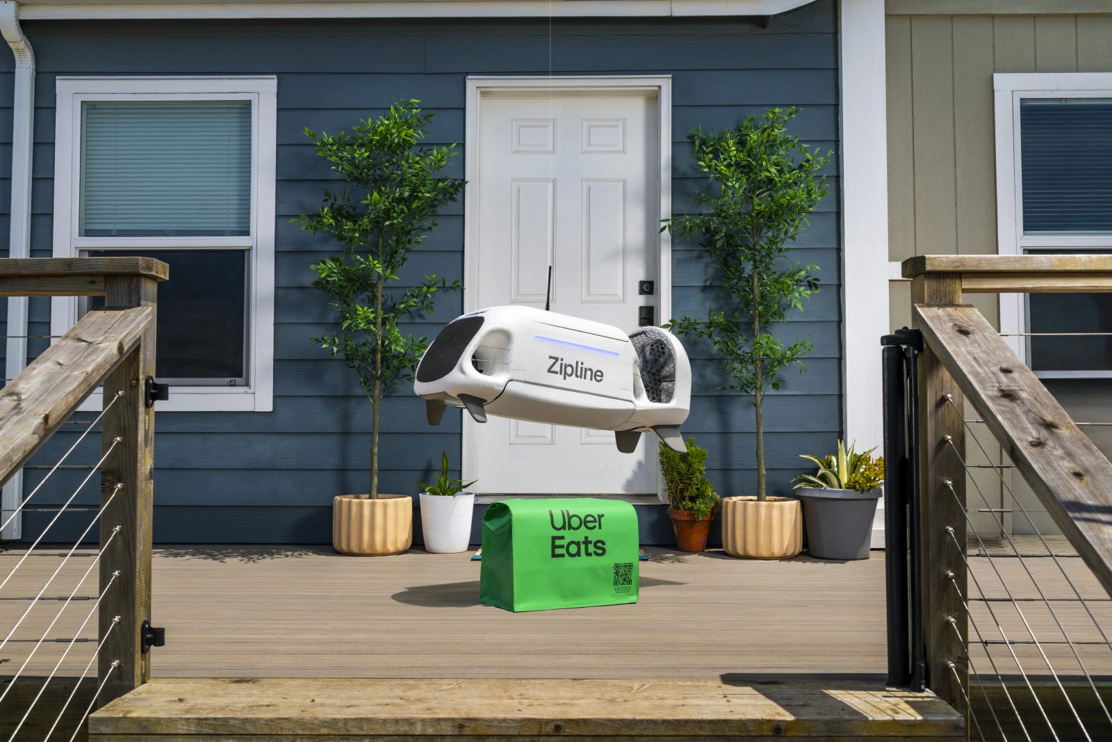 Zipline drone delivering an Uber Eats package to a house deck.