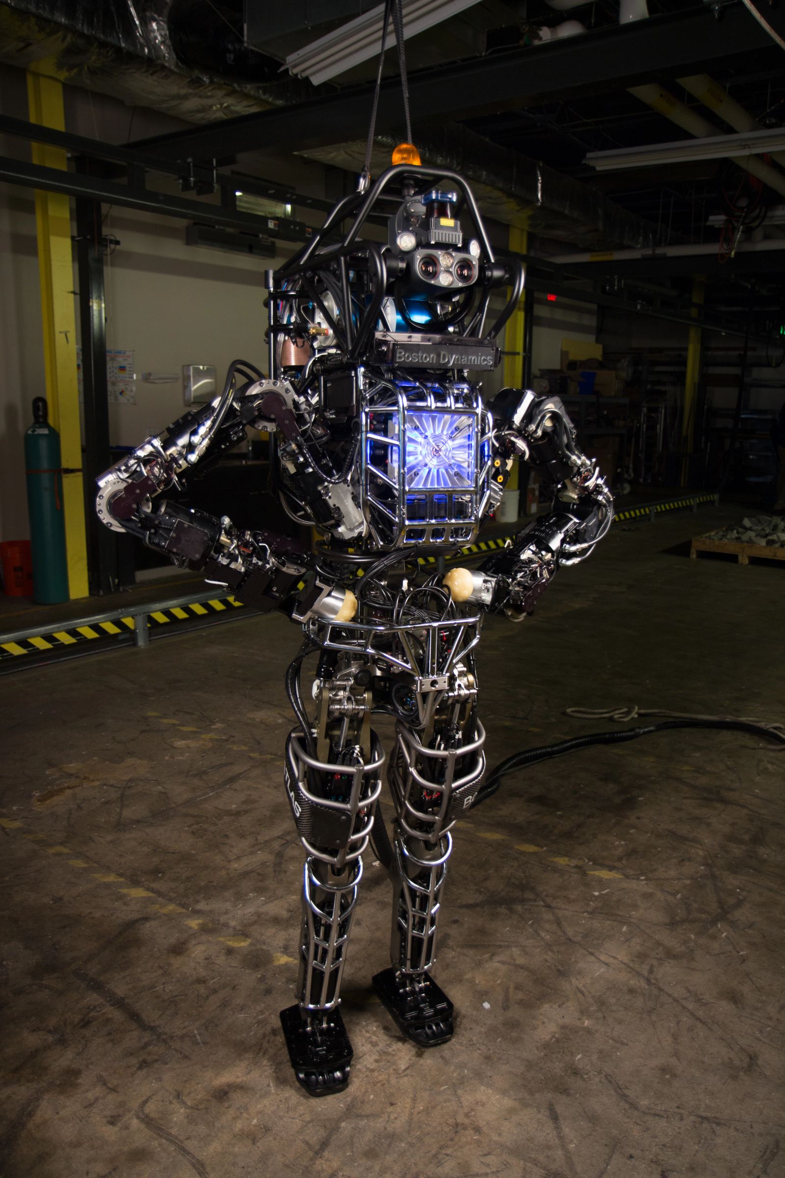 High-resolution laboratory photograph of the bipedal humanoid Atlas robot undergoing physical balance and articulation testing