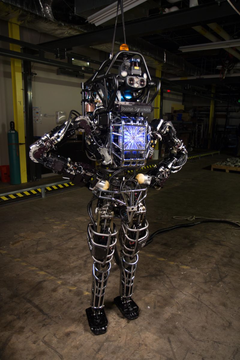 High-resolution laboratory photograph of the bipedal humanoid Atlas robot undergoing physical balance and articulation testing