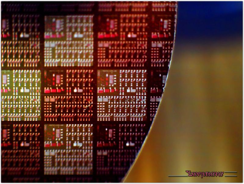 Patterned silicon wafer showcasing microscopic semiconductor die grids manufactured through advanced photolithography nodes.