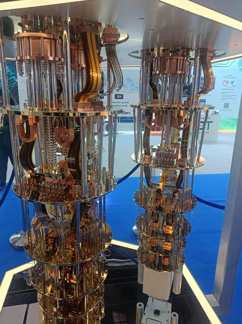 IBM quantum computing demonstration installation featuring cryogenic dilution refrigerator and microwave control electronics.