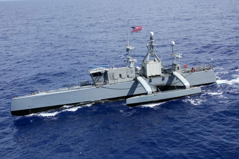 USV Sea Hunter medium unmanned surface vessel navigating in formation alongside naval battle groups during maritime operational trials