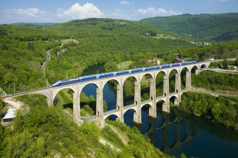 High-speed passenger train crossing a viaduct reflecting multi-modal transit networks in transport simulators