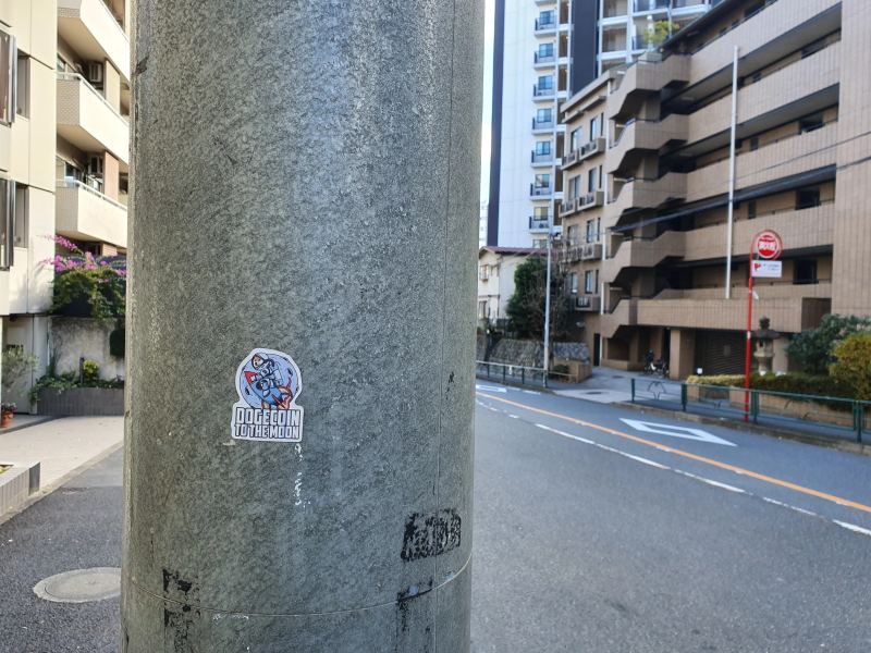 Dogecoin-Community-Aufkleber in Tokio, der die Erweiterung des Ökosystems für digitale Währungen darstellt