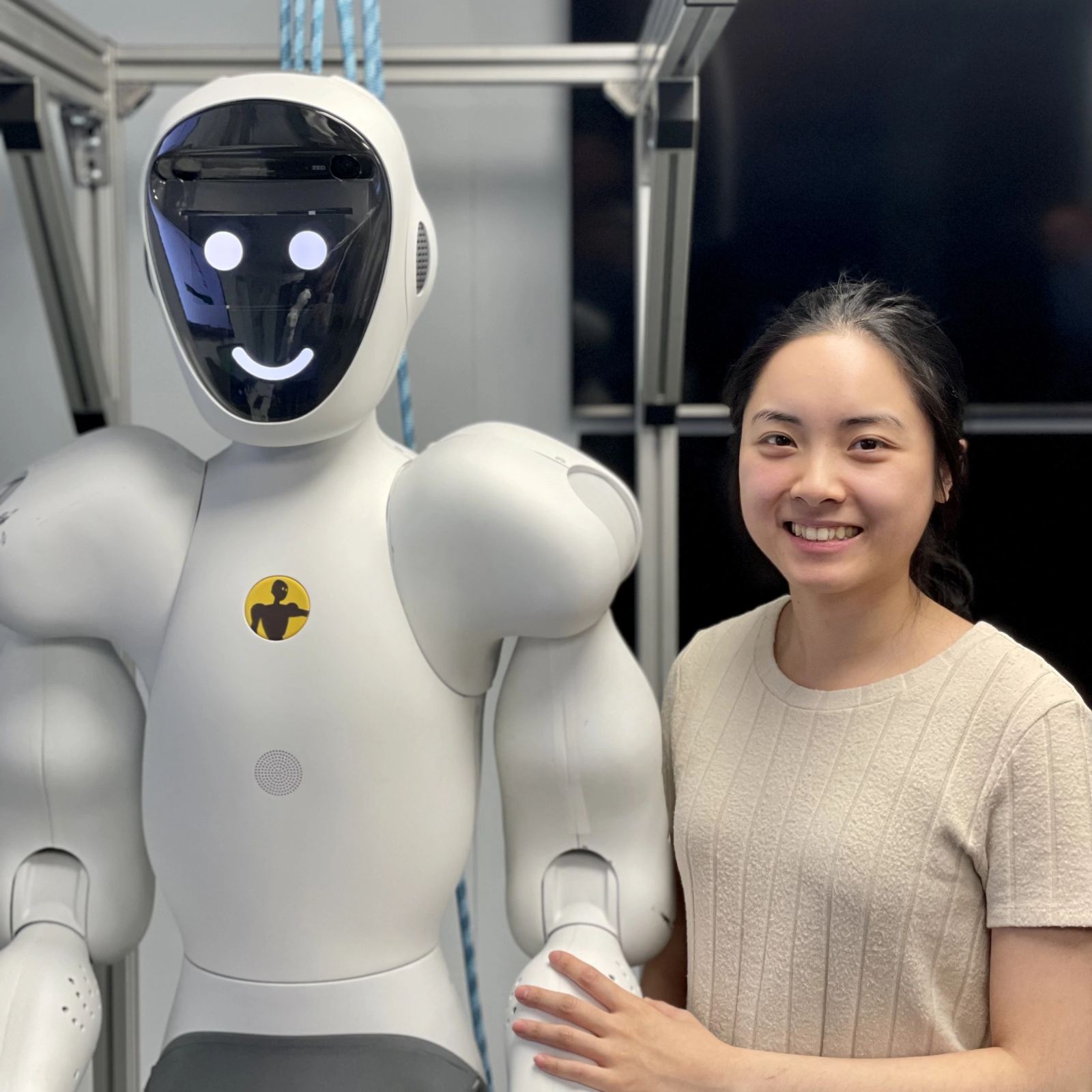 Humanoid collaborative robot in development laboratory being evaluated by robotics engineers