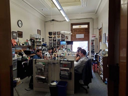 Modern multimedia newsroom workspace with editorial workstations and journalists tracking breaking news feeds