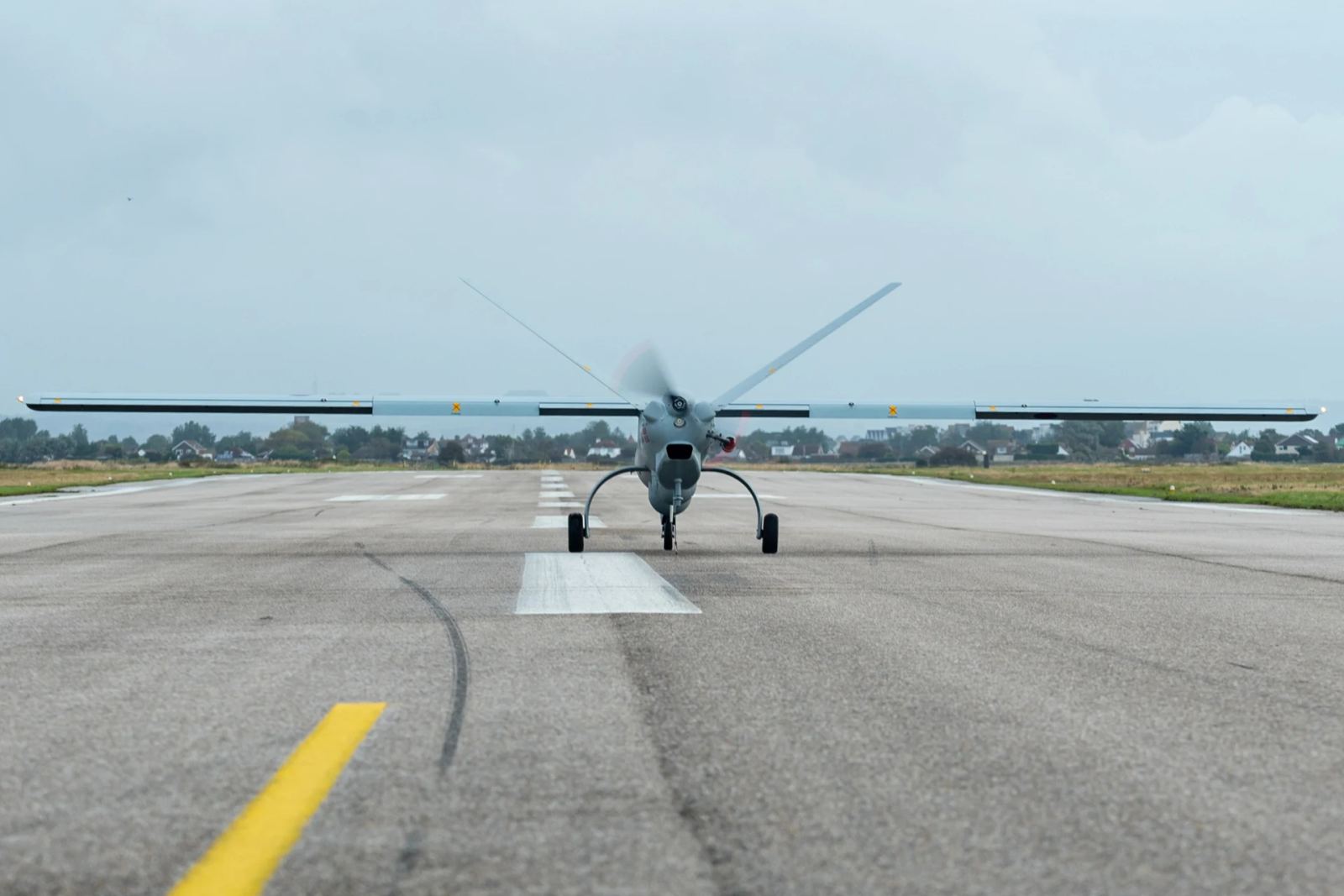 Unmanned aerial vehicle on military runway preparing for autonomous flight surveillance mission