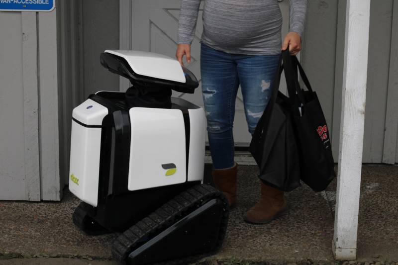 Autonomer elektrischer Lieferroboter für den Bürgersteig, der Fußgängerwege für die kontaktlose Abwicklung im Einzelhandel navigiert.