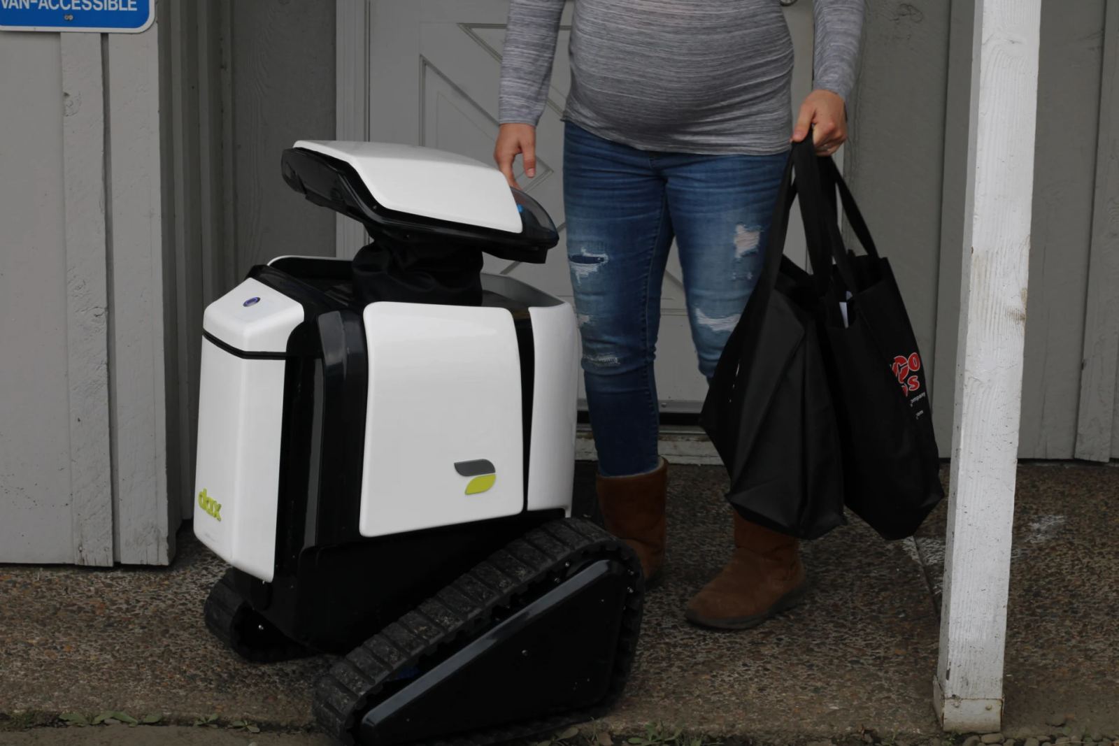 Autonomous electric sidewalk delivery robot navigating pedestrian pathways for contactless retail fulfillment.