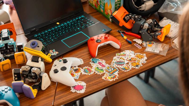 Official workbench photo shows physical MicroDuck robots with controllers and a development laptop.