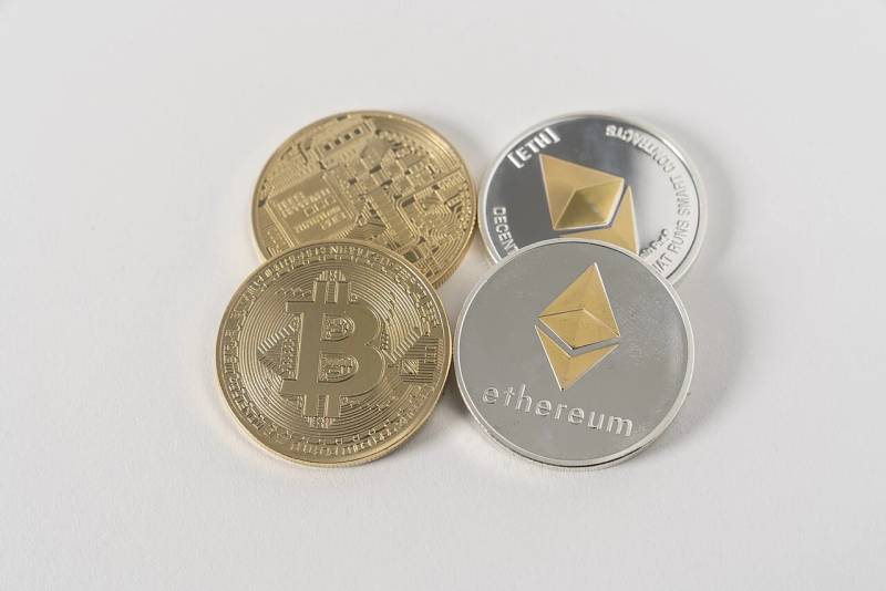 Decentralized digital token physical representations resting on a dark reflective surface.