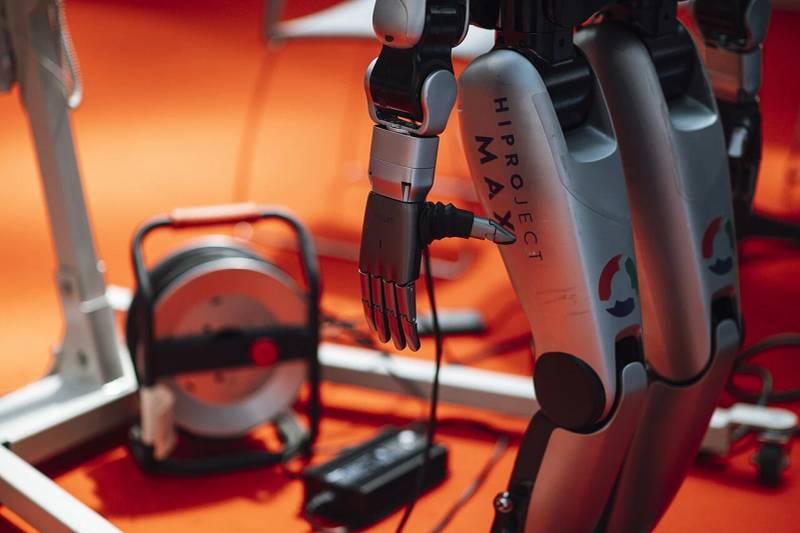 Advanced anthropomorphic robotic hand with multi-joint articulating fingers grasping an industrial tool, illustrating humanoid fine manipulation capabilities.