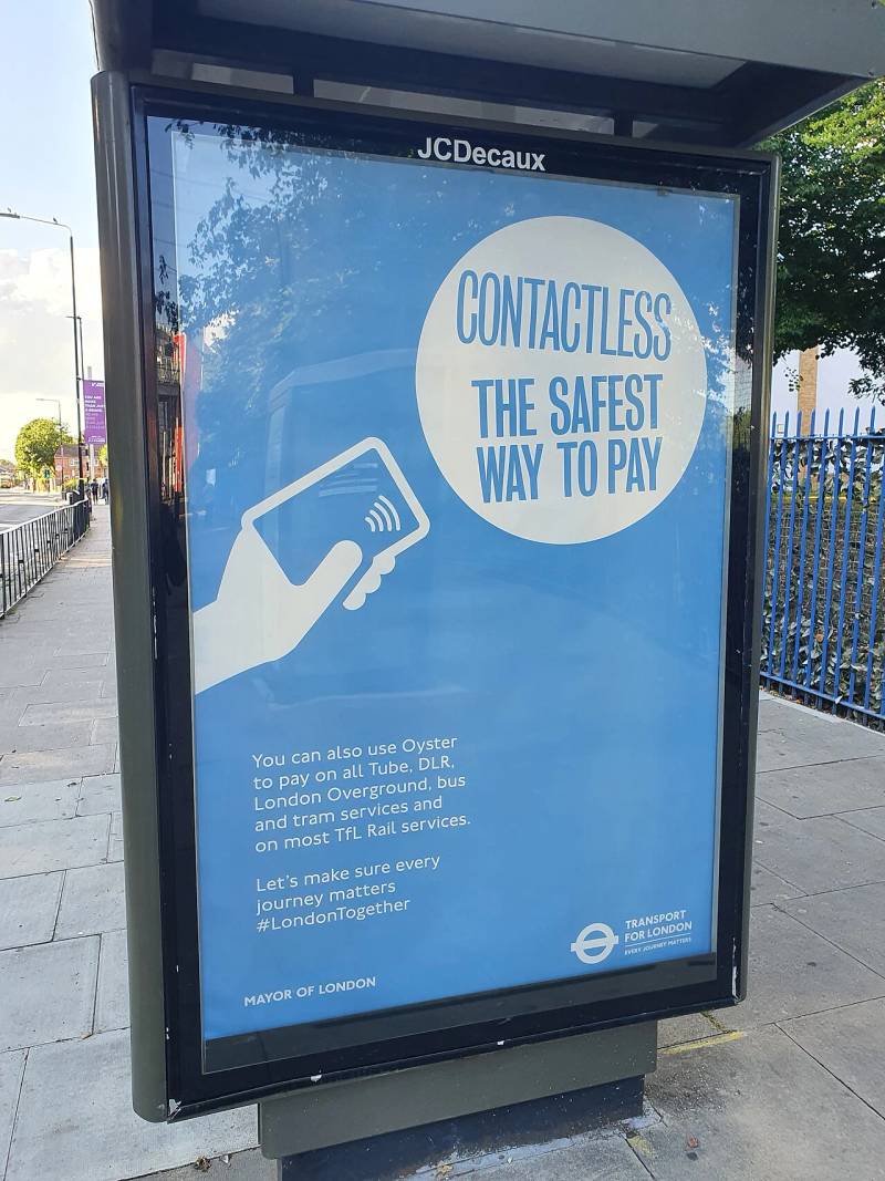 Public transit contactless payment signage highlighting the worldwide shift toward seamless tap and digital money transfer.