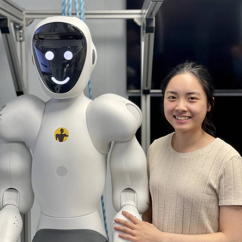Robotics engineer fine-tuning a humanoid collaborative robot platform for industrial laboratory inspection.